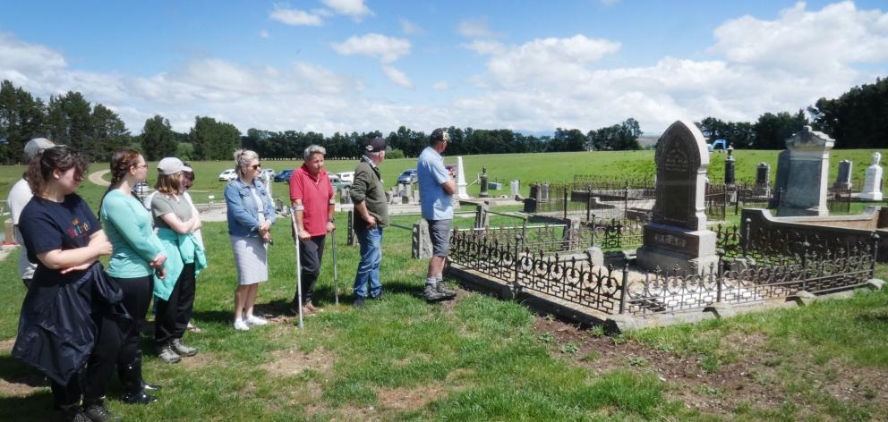 Some local residents observe a blessing and prayer ceremony at Drybread Cemetery on Monday,...