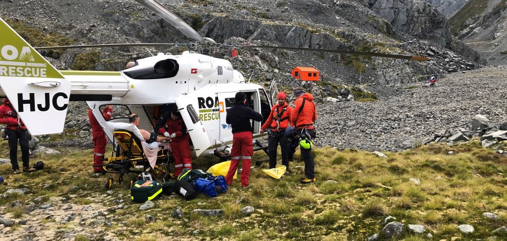 An injured climber is put into a helicopter after being lowered to a safe location and receiving...
