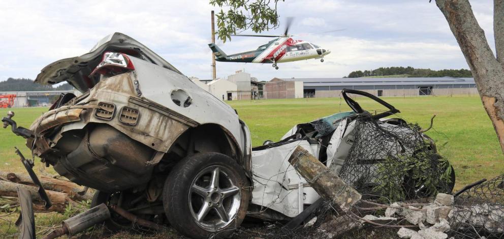 The Northland Rescue Helicopter lifts off from the freezing works grounds with the wrecked car in the foreground. Photo: Peter de Graaf