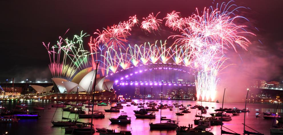 Fireworks explode over the Sydney Opera House and Sydney Harbour Bridge to celebrate New Year's...