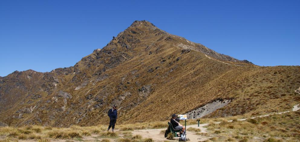 Trampers have a rest on Ben Lomond Saddle with the peak towering above them. PHOTO: ALINA SUCHANSKI