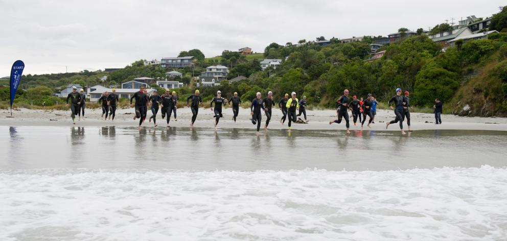 Competitors sprint for the waves at the start of the Otago Triathlon Championship at Brighton...