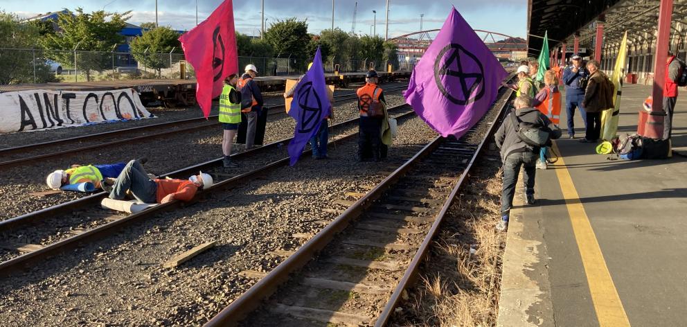 Activists against coal mining lay on the tracks at the Dunedin Railway Station this morning. Photo: Stephen Jaquiery
