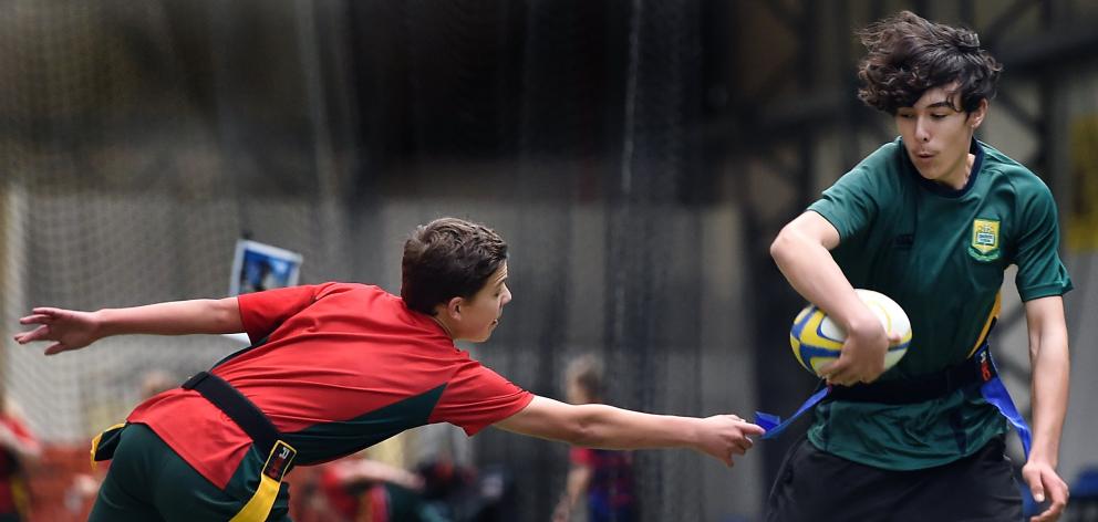 Levi Baxter (15), of Bayfield High School, attempts to evade the outstretched hand of Callum Low ...