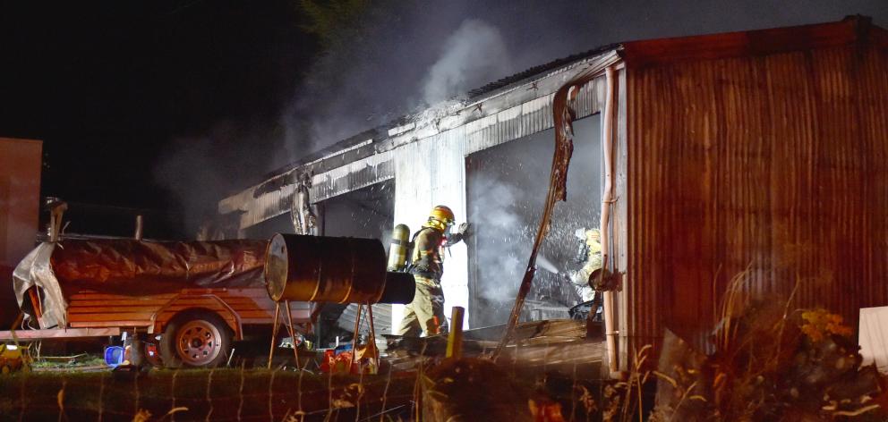 Firefighters work on a fire in a three-bay garage in Halfway Bush last night. Photo: Gregor Richardson