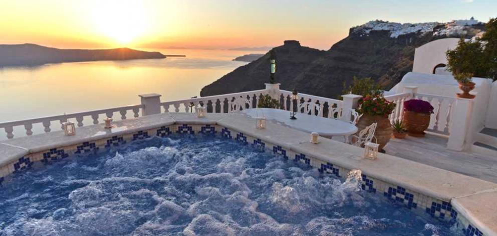 Sunset from the jacuzzi at our Santorini Love Home Swap with Skaros Rock and the villages of...