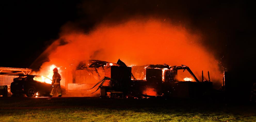 Flames engulf the Waitati house as firefighters do what they can. PHOTOS: STEPHEN JAQUIERY