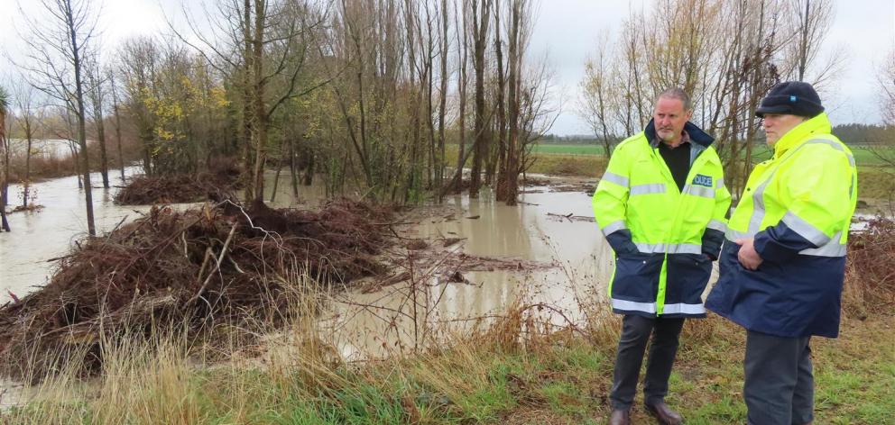 Ashburton District Councillor Angus McKay (right) talks with police at Digby's Bridge, where stopbanks were keeping floodwaters in the north branch of the Ashburton River. Photo: Ashburton Courier