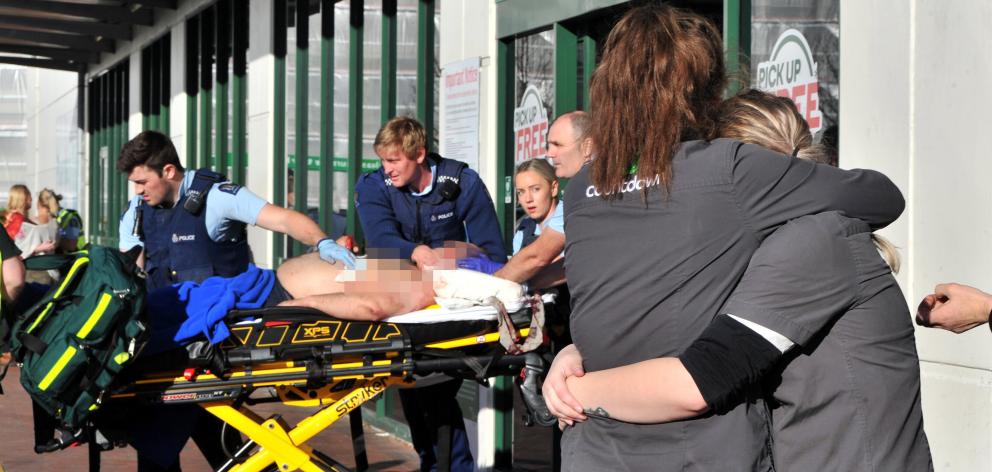 Countdown staff comfort each other as a stabbing victim is rushed to an ambulance outside the...