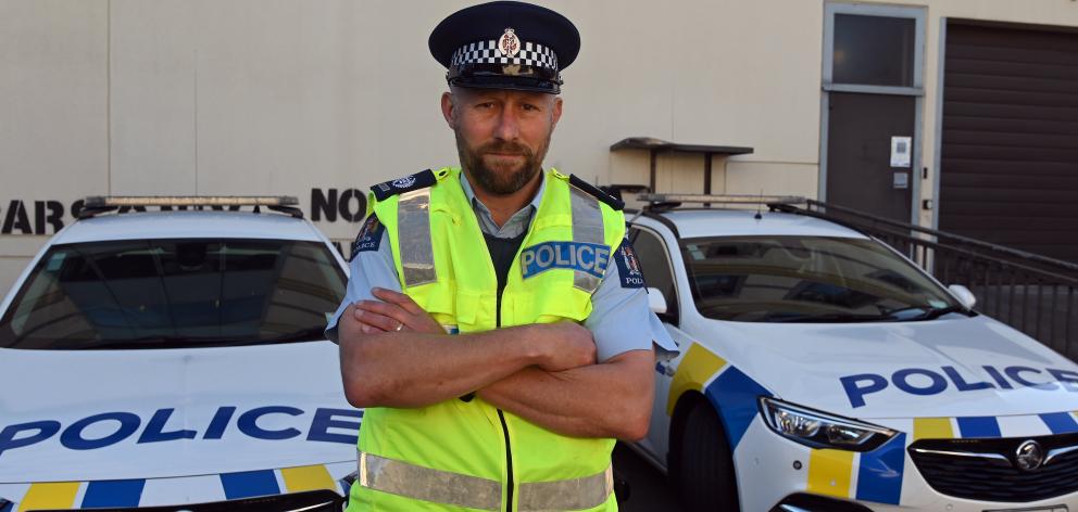 Standing before a pair of police cars in Dunedin, Otago coastal road policing manager Senior...