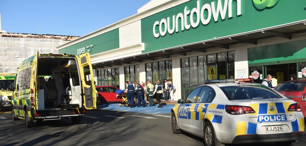 A stabbing victim is rushed to a waiting ambulance outside Dunedin's central city Countdown....