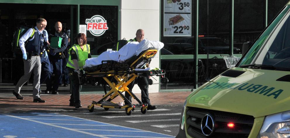 A patient is wheeled to an ambulance after the stabbing in Countdown Dunedin Central today. Photo: Christine O'Connor