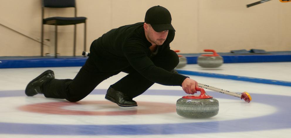 Anton Hood delivers a  stone during a match at the New Zealand Curling Championships in Naseby 
...
