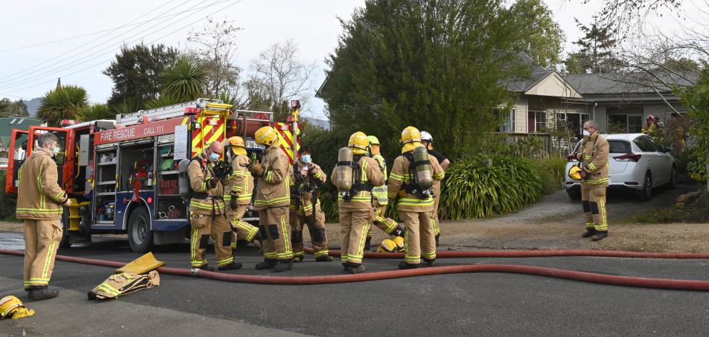 Fire and Emergency New Zealand firefighters mop up after a house fire in Warrington on Saturday...