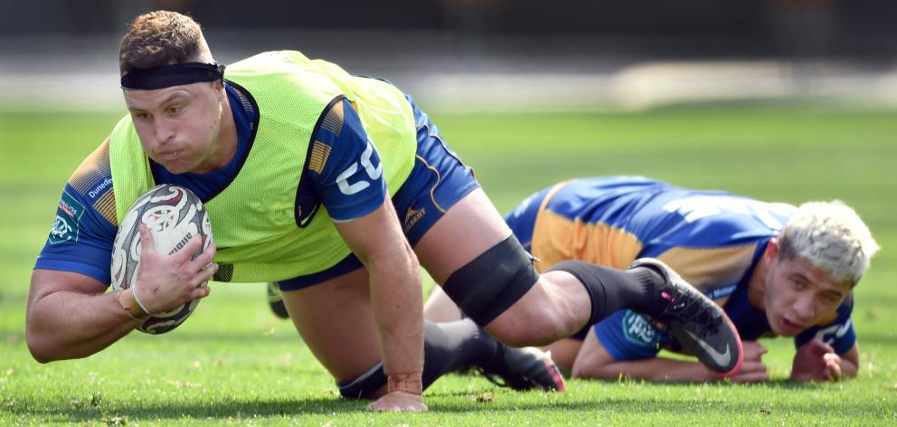 Dylan Nel takes the ball to ground as Freedom Vahaakolo watches at an Otago training session at...