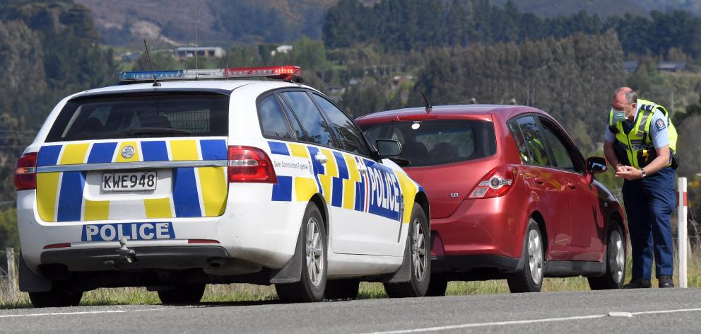 Senior Constable Brent Christie tickets a speeding driver on State Highway 1 near Waitati.PHOTO:...