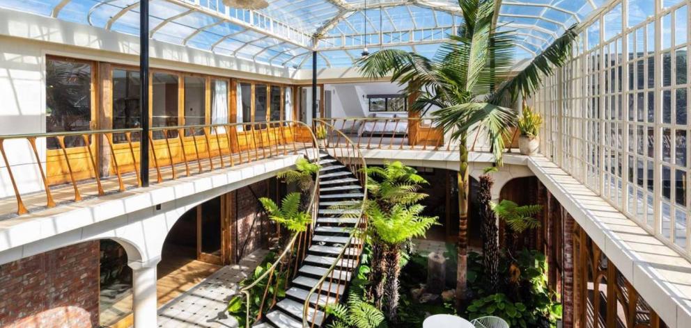 The spectacular glass conservatory and curved marble staircase. Photo: Supplied