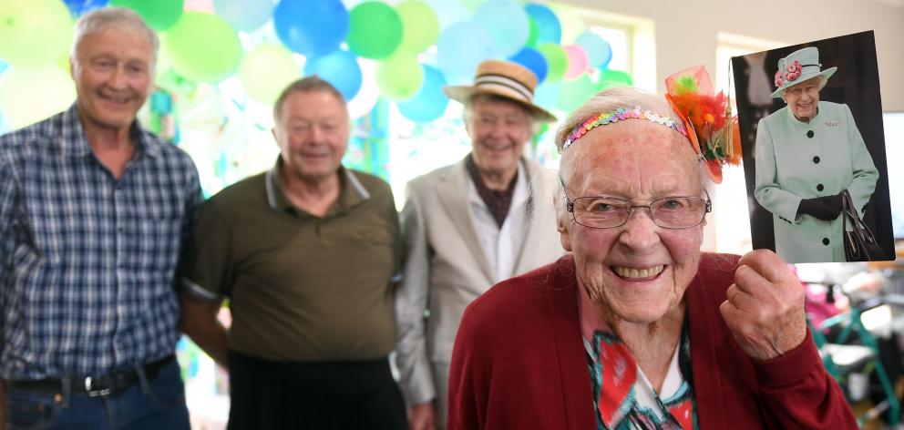 Connie Nelson proudly shows off her card from the Queen at her birthday party with three of her...
