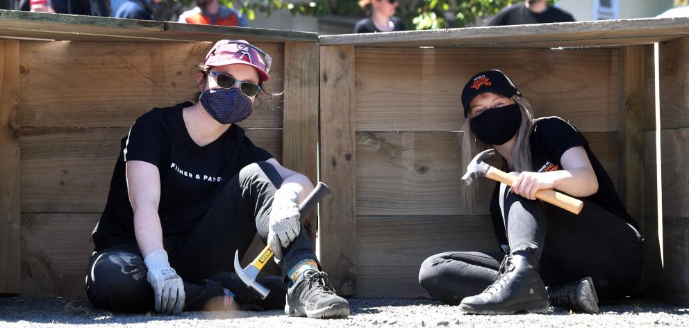 Elise Fairholm (left), of Fisher & Paykel, and Tayla Masson, of Mitre 10, sit in penguin boxes...