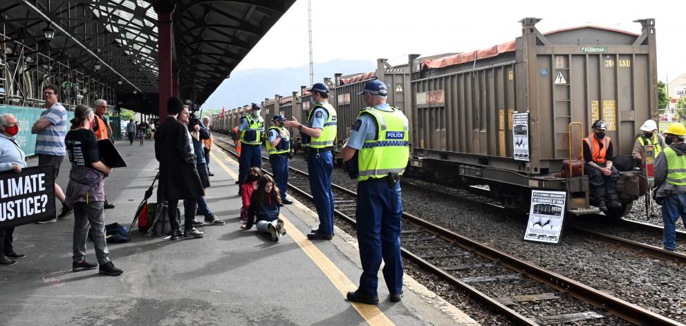 Police keep the public off the tracks while Extinction Rebellion protesters halt a coal train at...