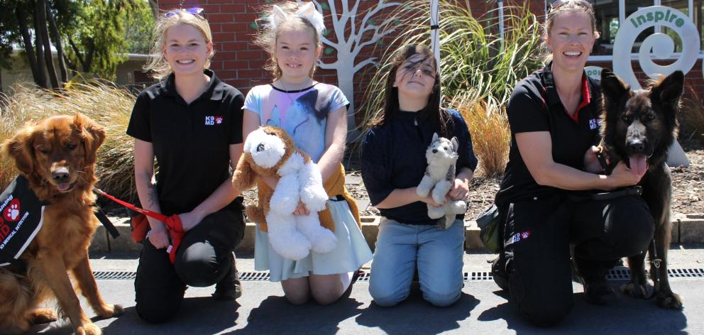 Zoey Hill (9, centre left) and Georgia Fehsenfeld (8) meet medical detection dogs Magic (2, left)...