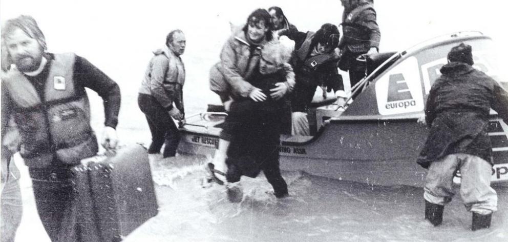 Rescuing people during the 1980 Taieri Flood are Terry Low and Alan McNaughton as Rowan Leck carries an unknown woman. Photo: Taieri Herald Rescuing people during the 1980 Taieri Flood are Terry Low and Alan McNaughton as Rowan Leck carries an unknown woman. Photo: Taieri Herald