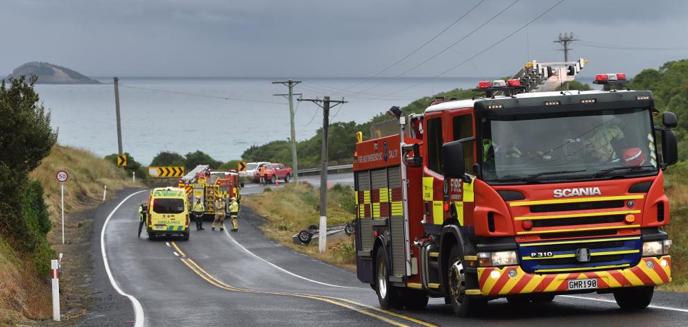 Emergency services assist a woman who’s car rolled near the entrance to Blackhead Quarry this afternoon. Photo: Christine O'Connor Emergency services assist a woman who’s car rolled near the entrance to Blackhead Quarry this afternoon. Photo: Christine O'Connor