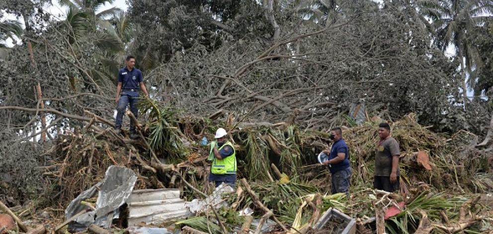 A search and rescue team combs through the wreckage in Haatafu on the western coast of Tonga's...