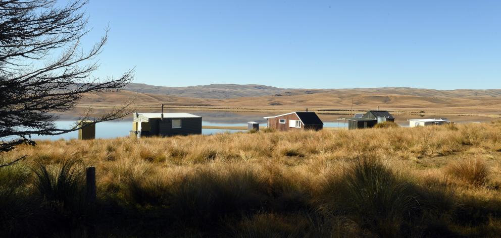 Huts dot the lakeside landscape.