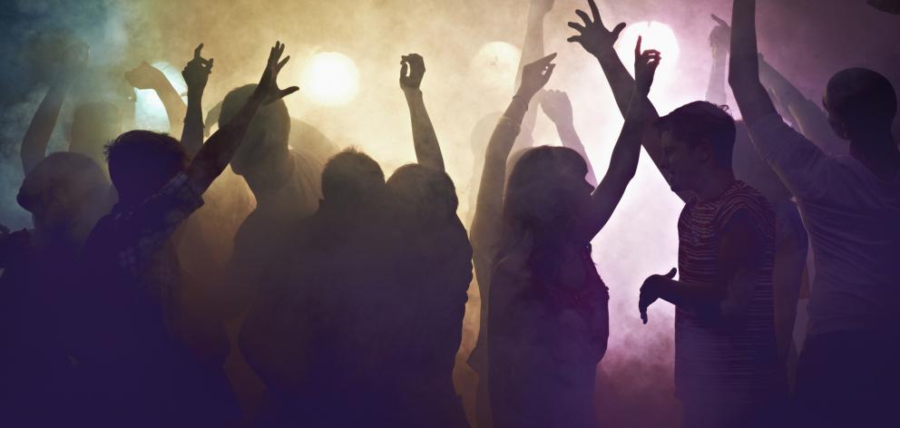 Young people dance at a party or concert. Photo: Getty Images