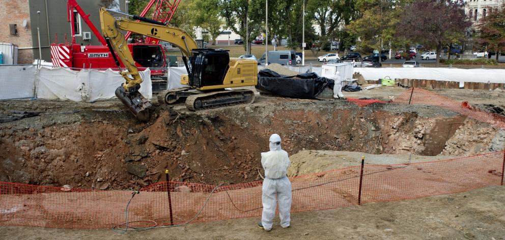 A staff member looks on as an excavator removes soil and fill on the ACC site in Dowling St. The...