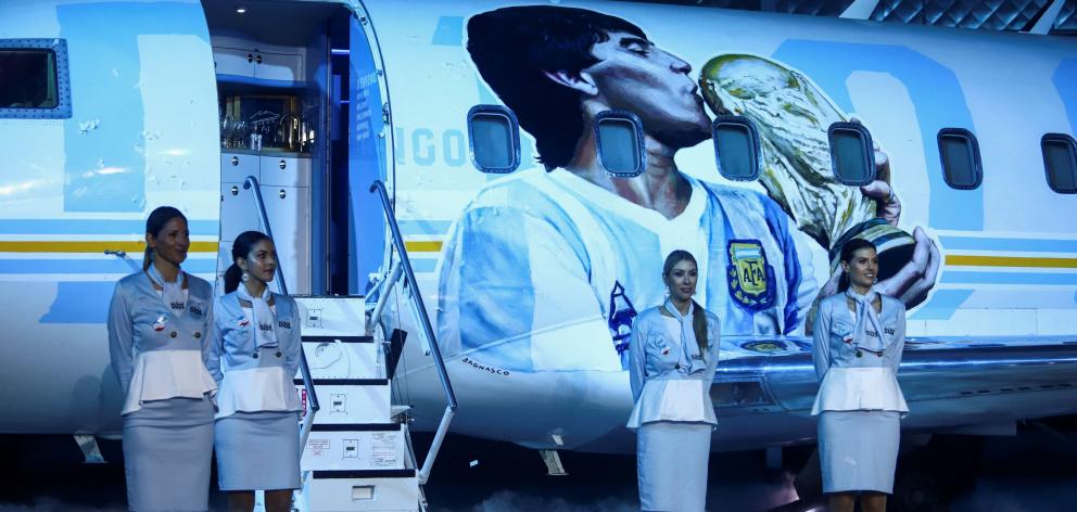 The aircraft features a picture of Maradona kissing the World Cup trophy on the fuselage, while...