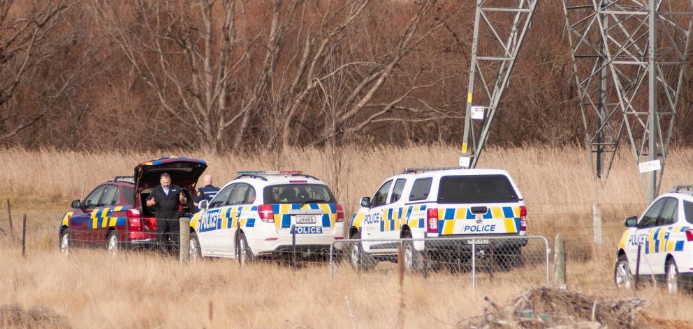 Police by a closed section of Tamblyn Dr in the Roxburgh Hydro Village conduct a search for a...