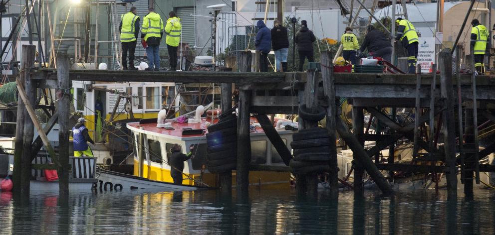 Firefighters pump water from Carey’s Bay-based fishing vessel Echo after it sank at its mooring...