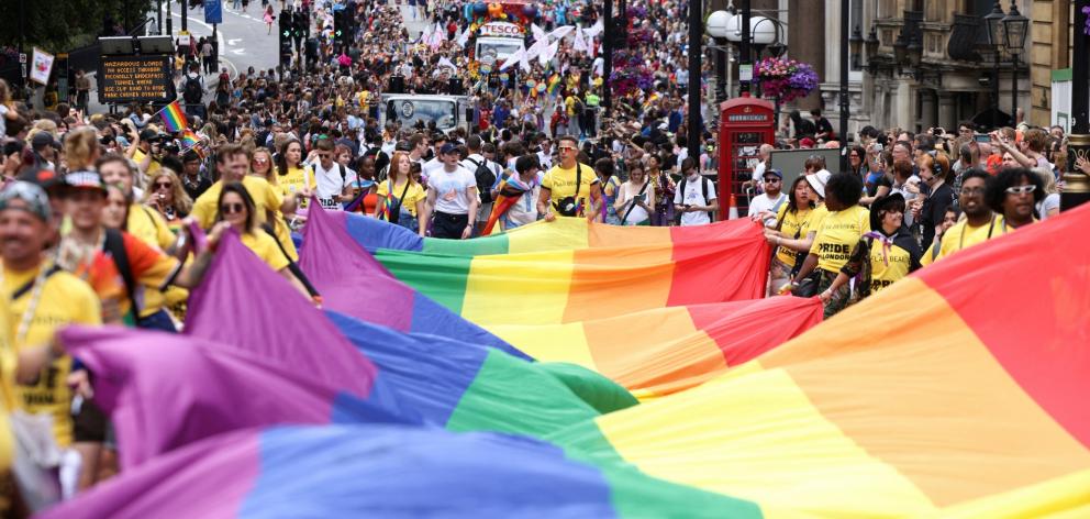 A large rainbow flag is carried along a central London street. Photo: Reuters 