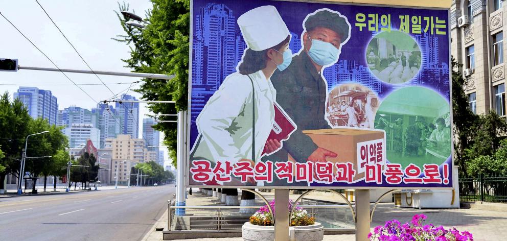 A sign depicting a scene of medical products transportation on an empty street in North Korea....