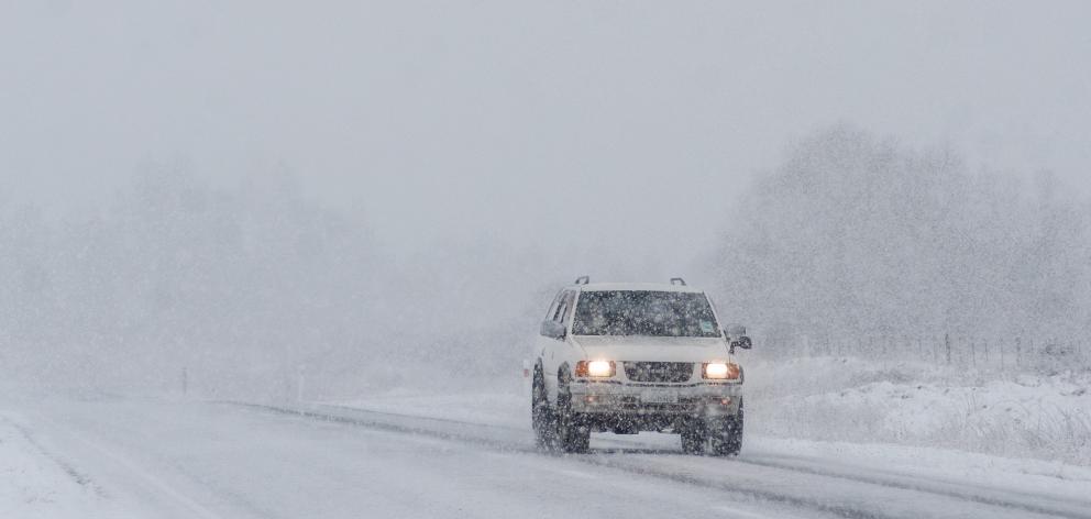 A motorist navigates State Highway 85 near Wedderburn while blowing snow hampers visibility....