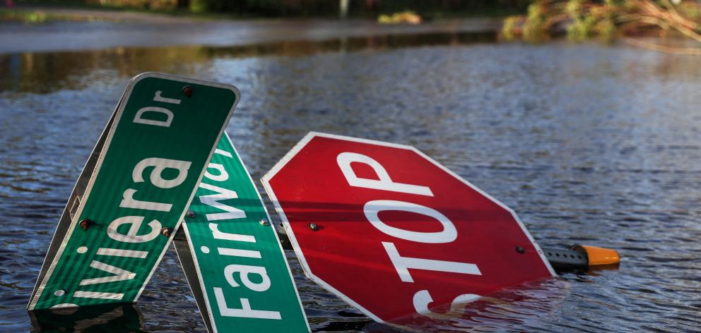 A street sign lies in flood waters after Hurricane Ian made landfall in Punta Gorda, south-west...