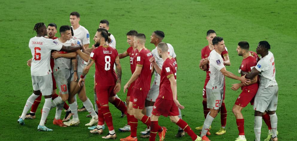Swiss captain Granit Xhaka (left) and Serbia striker Aleksandar Mitrović are held back during a...