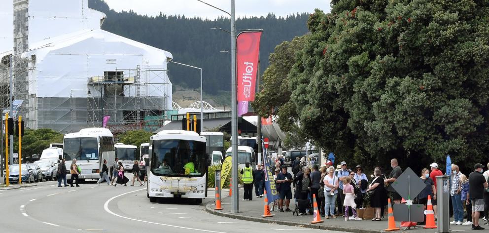 Cruise ship passengers await transportation on shuttle services outside the Toitu Otago Settlers...