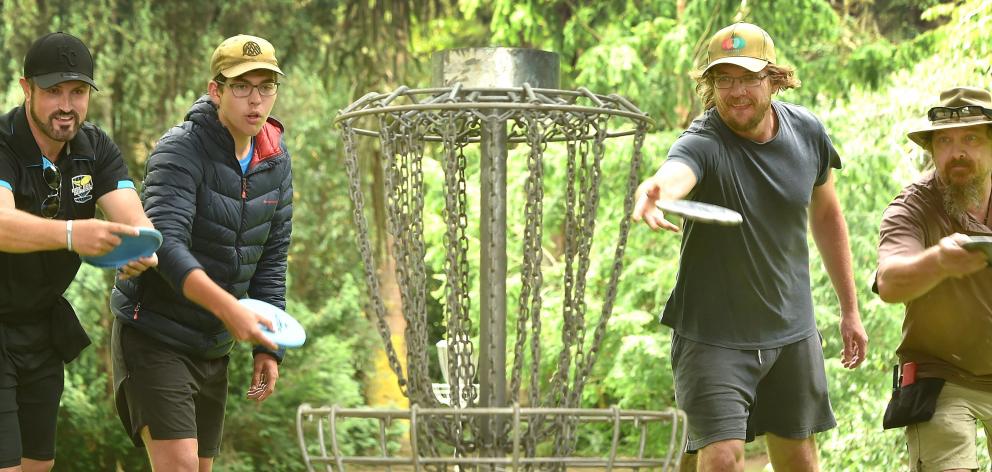 Throwing their discs into the basket at the Chingford Park disc golf course are Disc Golf Dunedin...
