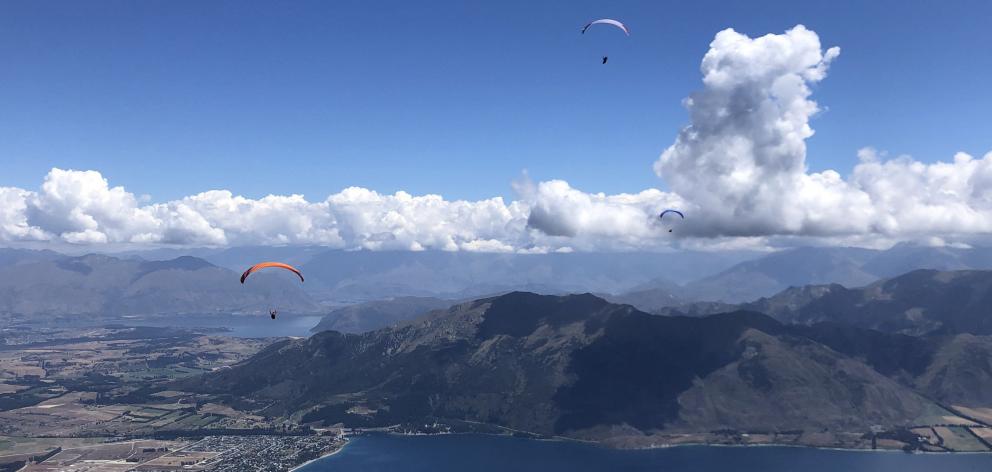 Paragliders taking part in the NZ Paragliding Open at Wanaka fly over Lake Hawea as part of a...