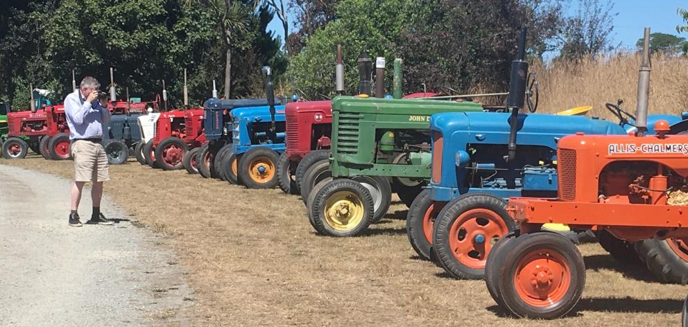 An admirer takes a photo of the long row of heritage tractors displayed by the East Otago Vintage...