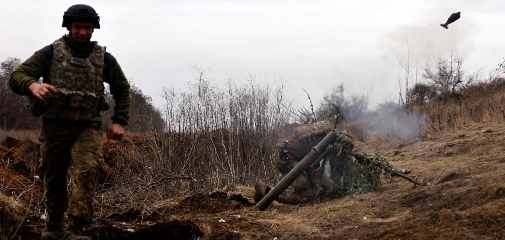 Ukrainian soldiers of the Paratroopers' of 80th brigade fire a mortar shell at a frontline...