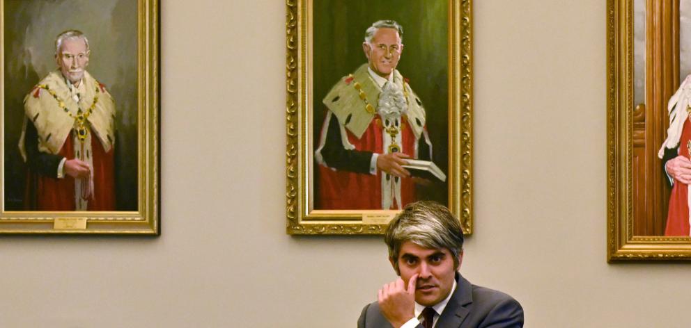 Former Dunedin Mayor Aaron Hawkins sits in front of mayoral portraits of early Dunedin mayors in...