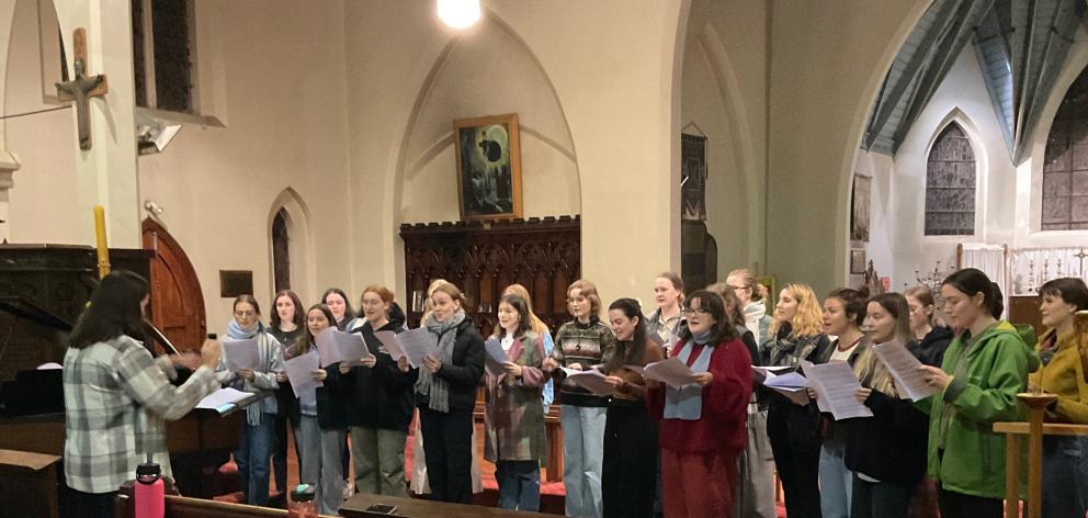 The women of the Southern Youth Choir rehearse a piece, with co-conductor Kaitlyn Freeman, in...