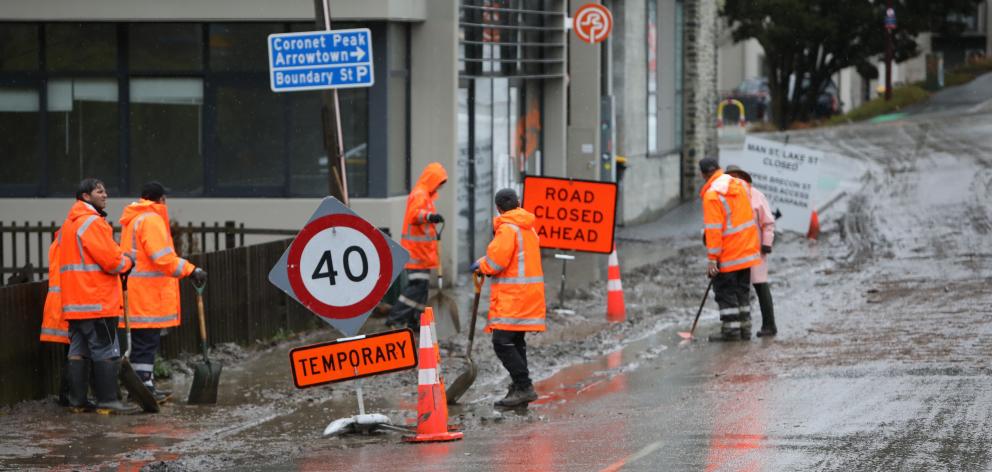 Workers clean up debris in central Queenstown yesterday. Photo: Rhyva van Onselen