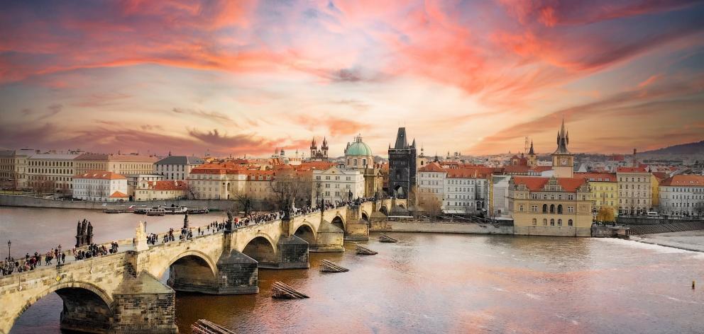 The sun sets on Prague, the capital city of the Czech Republic. The pedestrian Charles Bridge is...