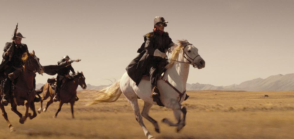 Jed Brophy, cast in part for his skill on a horse, leads a militia posse.