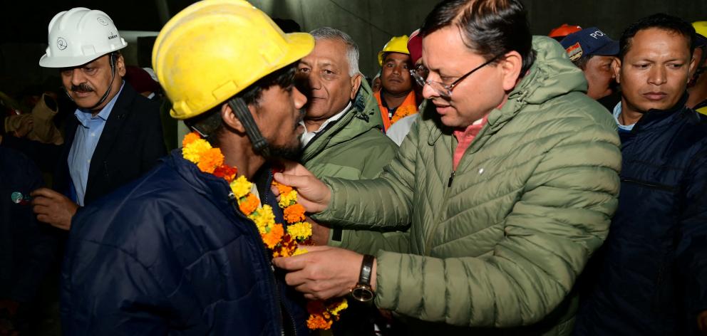 Pushkar Singh Dhami, Chief Minister of the northern state of Uttarakhand, greets a worker after...